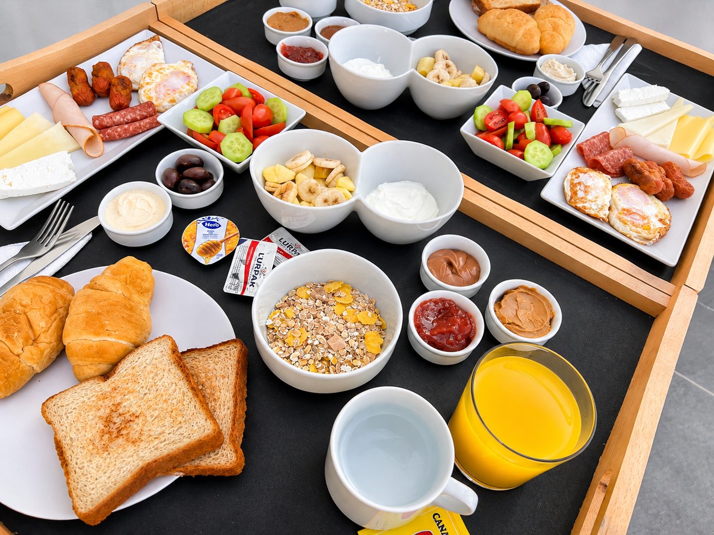 Breakfast trays with eggs, cheese, fresh fruit, yoghurt and pastries at Dragonfly Villas, Santorini