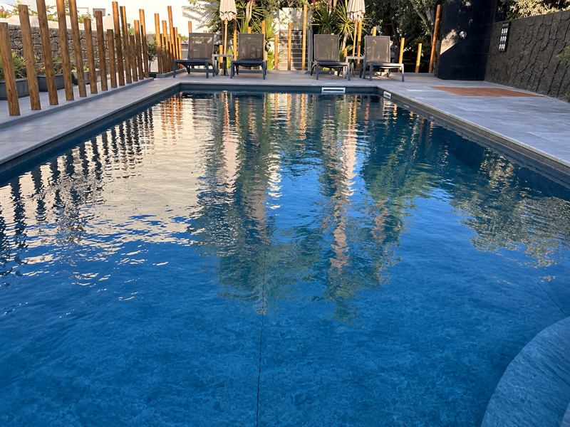 Clear pool water with reflections of the palms – Dragonfly Villas, Santorini