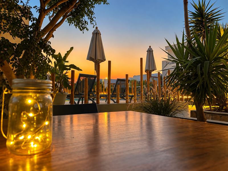 Terrace table with a lantern at dusk – Dragonfly Villas, Santorini