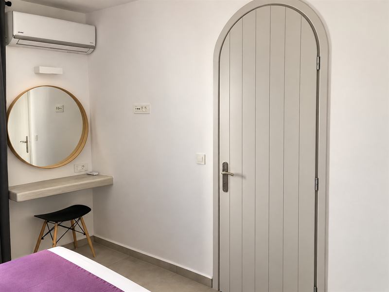 Suite – Outdoor Hot Tub – Bedroom with arched door, Dragonfly Villas Santorini